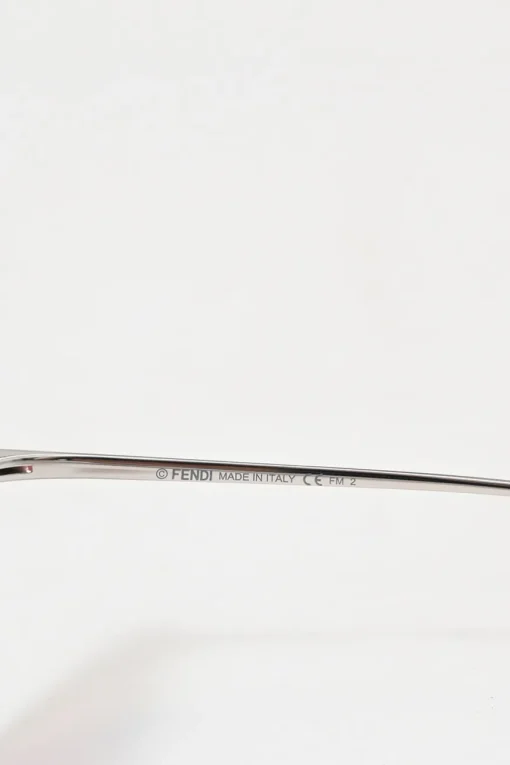 Silver-tone metal and pink tinted polycarbonate rimless cat-eye sunglasses with glitter accents