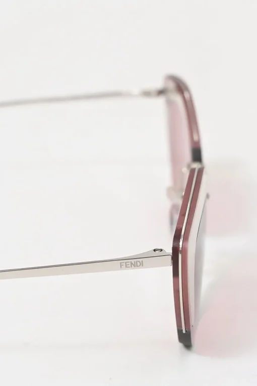 Silver-tone metal and pink tinted polycarbonate rimless cat-eye sunglasses with glitter accents
