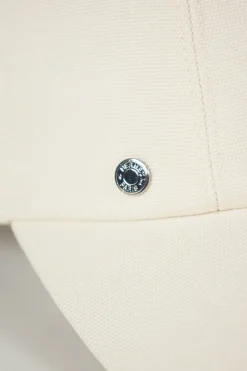 'Tess Cap' in off white cotton canvas with interior "Quadrige" badge and adjustment tab with two polished palladium plated Clou de Selle details