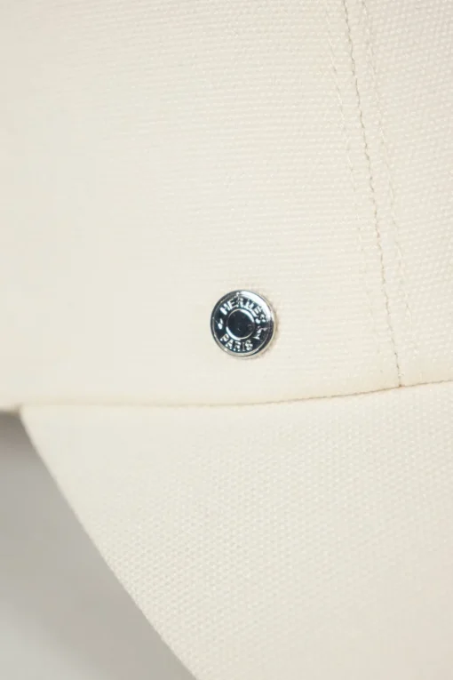 'Tess Cap' in off white cotton canvas with interior "Quadrige" badge and adjustment tab with two polished palladium plated Clou de Selle details