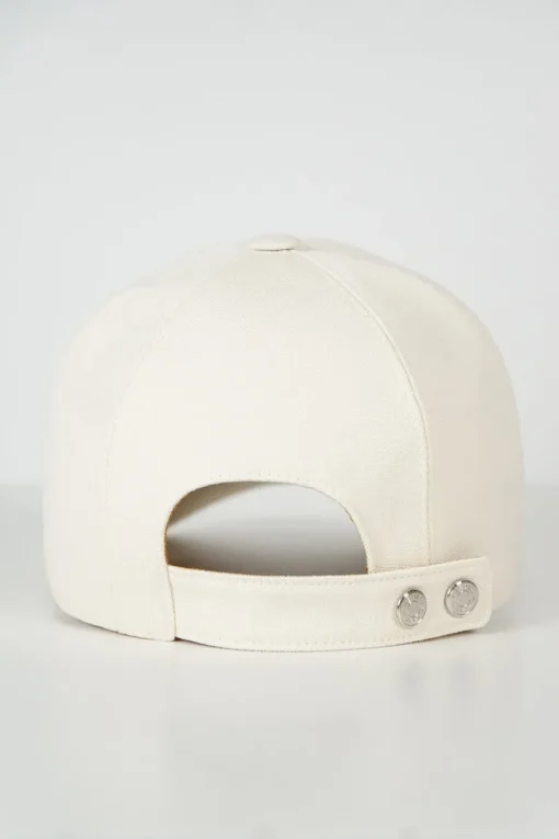 'Tess Cap' in off white cotton canvas with interior "Quadrige" badge and adjustment tab with two polished palladium plated Clou de Selle details
