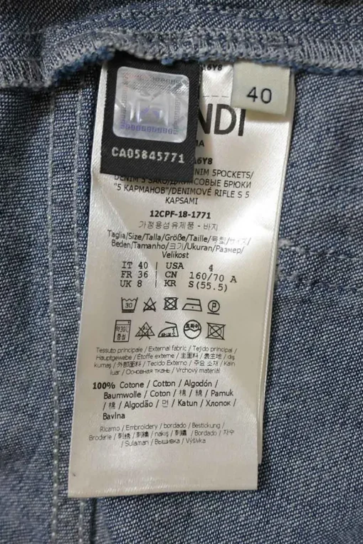 True indigo cotton denim paper-bag waist tapered leg pants with snap buckle belt and tab cuffs
