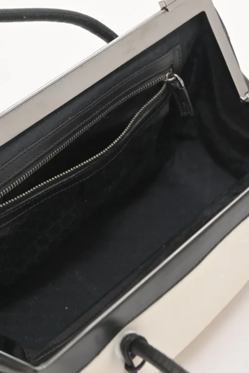 Two-tone canvas and leather frame shoulder bag with metallic push-lock closure