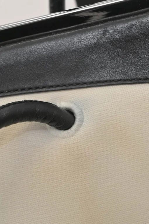 Two-tone canvas and leather frame shoulder bag with metallic push-lock closure