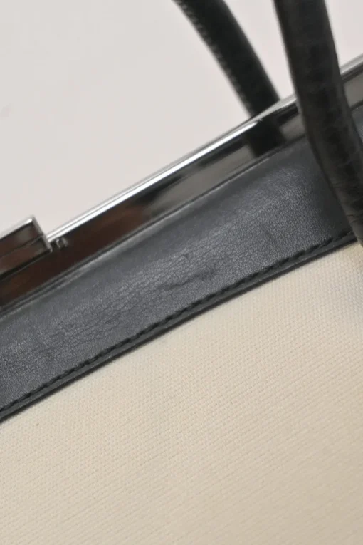 Two-tone canvas and leather frame shoulder bag with metallic push-lock closure