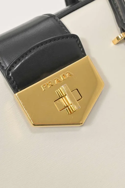 Two-tone leather top handle bag with turnlock fastening