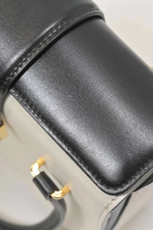 Two-tone leather top handle bag with turnlock fastening