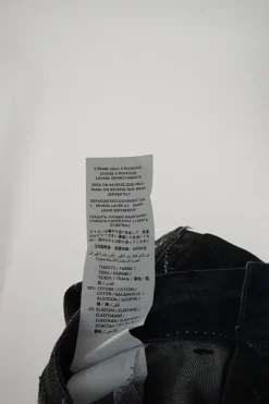 Washed black raw edge cotton-blend denim mini skirt featuring metallic star motif
