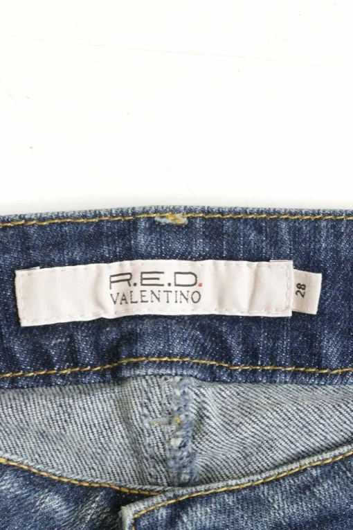 Washed indigo cotton-blend denim low-rise bootcut jeans featuring diamante V-logo plaque patch pockets