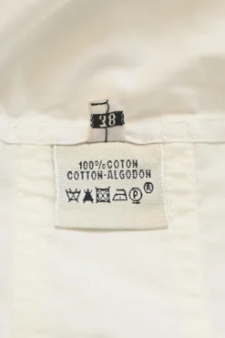 White cotton poplin point collar half-button tie-waist romper with turn-up cuffs