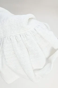 White cotton-blend textured drop-waist mini ruffle skirt with concealed rear zip fastening