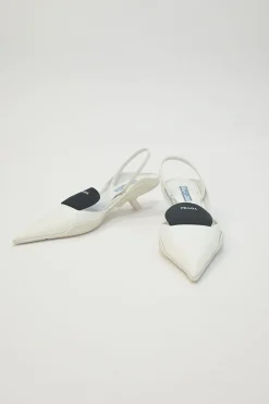 White fabric and rubber pointed-toe slingback court pumps with contrasting logo tongue