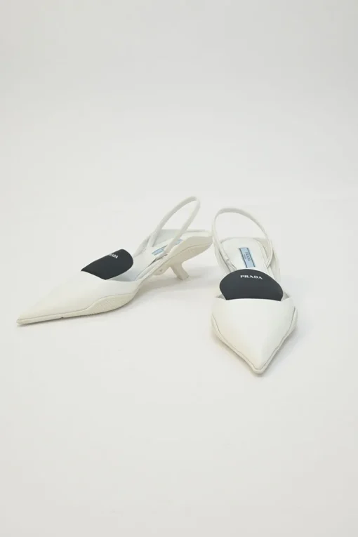White fabric and rubber pointed-toe slingback court pumps with contrasting logo tongue