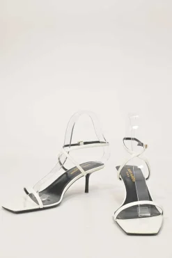 White patent leather low-heeled strappy sandals with criss-cross buckle strap fastening