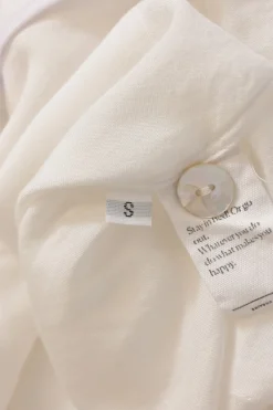 White viscose pyjama two-piece set featuring notch collar blouse and wide-leg lounge pants with detachable feather trim appliqué
