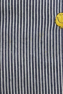 x Mr. Men Mr. Happy embroidered striped indigo cotton-blend denim button-front jumpsuit