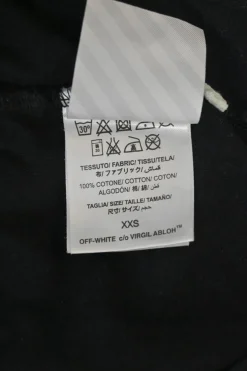 Black cotton jersey pullover T-shirt with spray paint logo at the front and signature diagonal stripe logo printed on the back