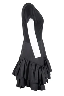 Black crew neck with folded hem short-sleeved mini dress. Adorned with layered flared pleated skirt and feature zipper closure on the side