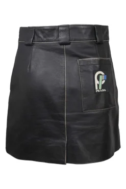 Black paneled leather mini skirt with belt loop waistband, hip patch pockets, and rear logo patch pocket appliqué