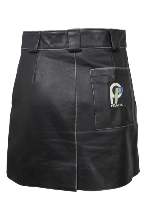 Black paneled leather mini skirt with belt loop waistband, hip patch pockets, and rear logo patch pocket appliqué