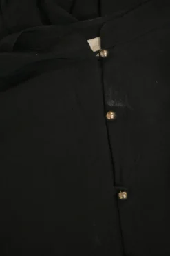 Black silk band collar half-button long sleeve tiered shift dress with metallic button loop fastening