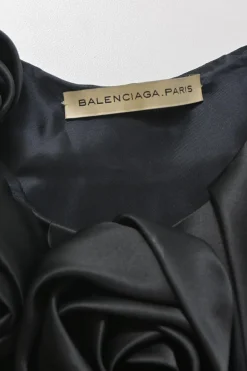 Black silk satin cocoon-style sleeveless balloon dress with rose appliqués at neckline