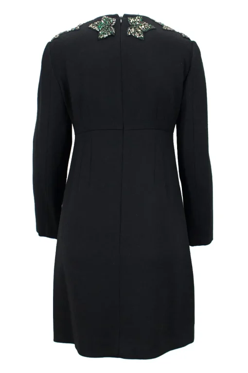 Black wool long sleeve mini dress with emerald and crystal stone embellishment around neckline, double pleated bodice for figure fit.