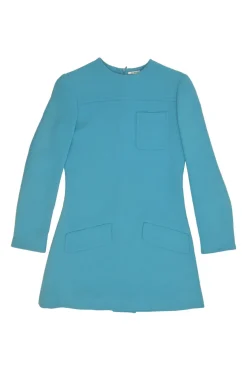 Blue long sleeve tailored blouse with chest patch, slanted hip flap pockets, and vented back