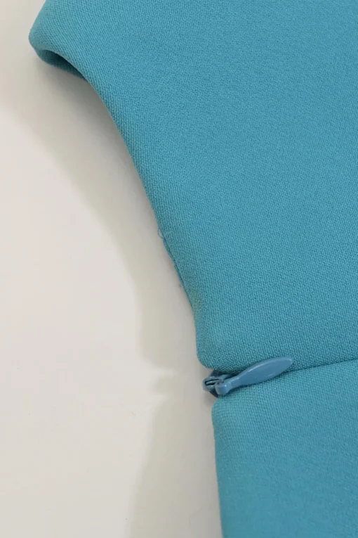 Blue long sleeve tailored blouse with chest patch, slanted hip flap pockets, and vented back