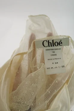 Cream cotton-silk plumette tulle spread collar pullover button-front tie-waist peplum top with flutter sleeves