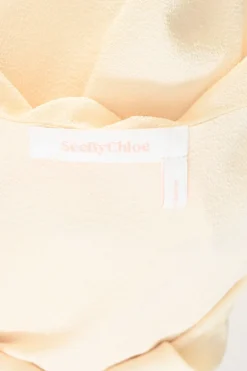 Cream draped polyester crêpe round collar bateau neck swing-style blouse with flounce cuffs
