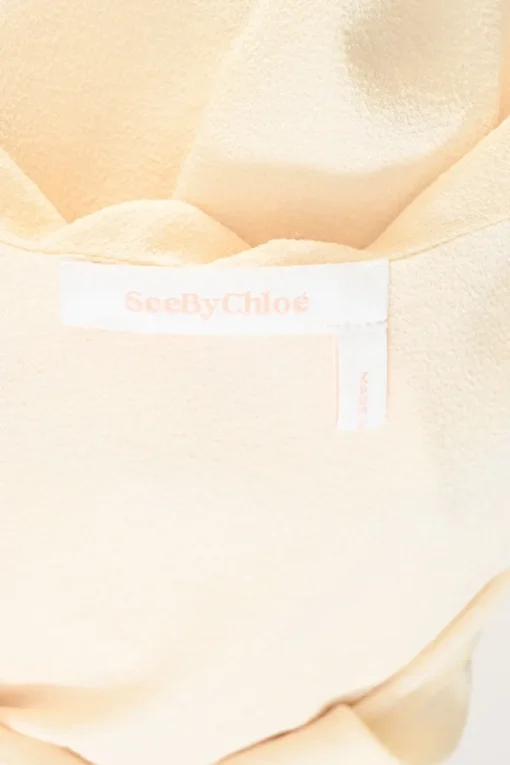 Cream draped polyester crêpe round collar bateau neck swing-style blouse with flounce cuffs