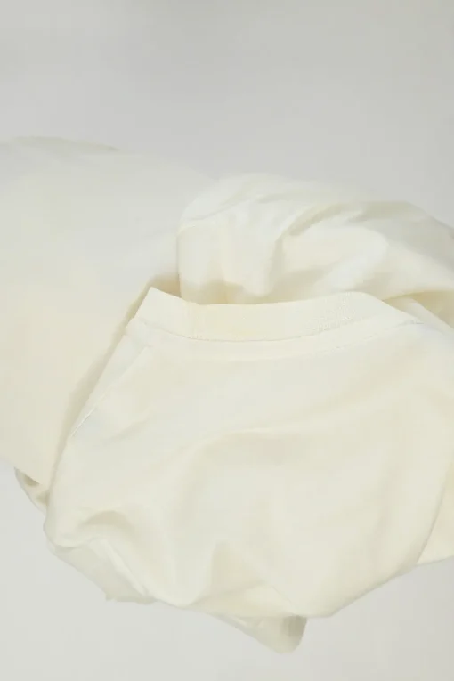 Ecru cotton and polyester mixed-media crewneck pullover T-shirt with lace insert and toggle hem