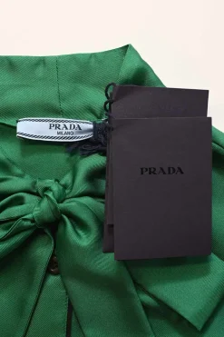 Emerald green silk satin button-front pussy-bow blouse with logo-embroidered chest patch pocket