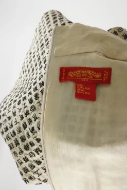 Ivory and black two-tone silk oracle bone script jacquard qipao sheath with frog button hip appliqué