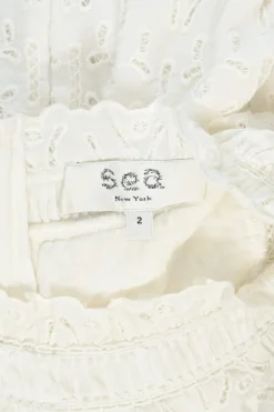 Ivory cotton broderie Anglaise ruffled high-collar sleeveless swing dress with tonal lace inserts