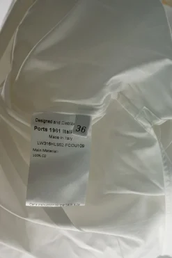 Ivory cotton poplin band collar wrap-front asymmetric apron-style shirt with self-tie fastening at waist
