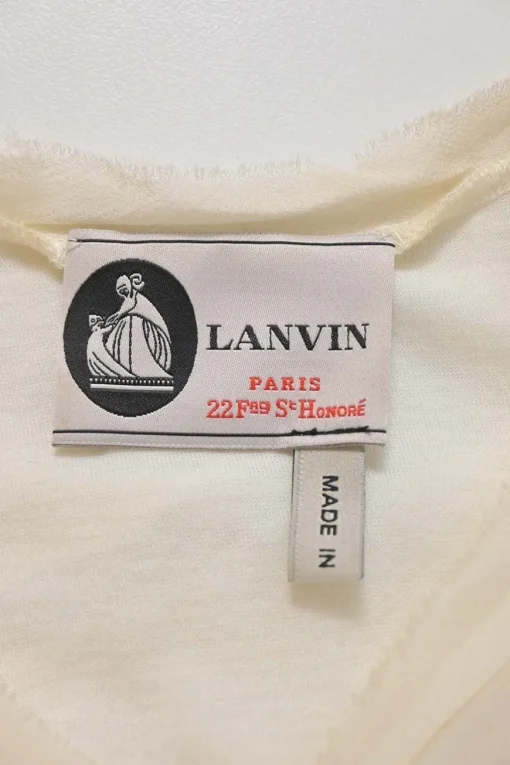Ivory cotton-blend cap sleeve blouse with raw-edge shoulder line frill trim appliqué