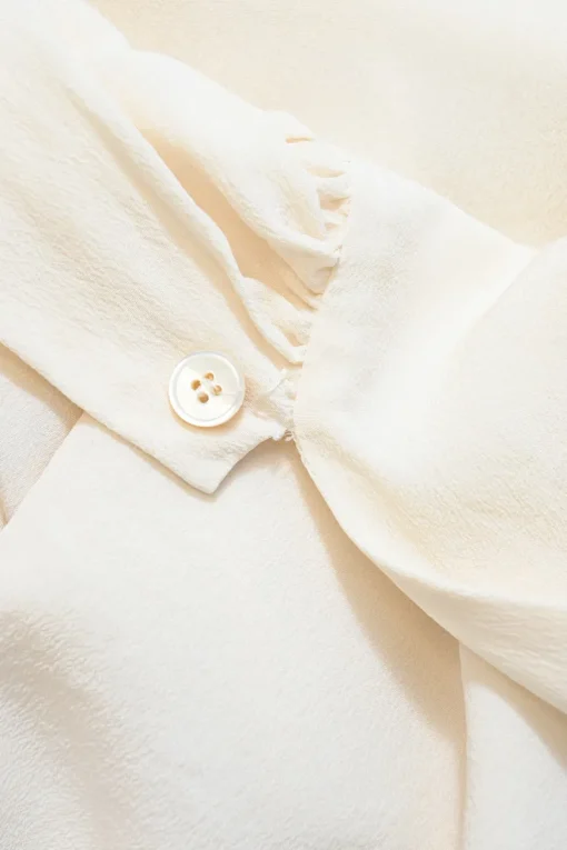 Ivory crepe round neck tie-waist blouson with concealed placket