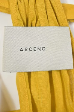 Mustard yellow draped organic linen Grecian neck swing-style shift dress with gathered neckline and self-tie fastening at nape
