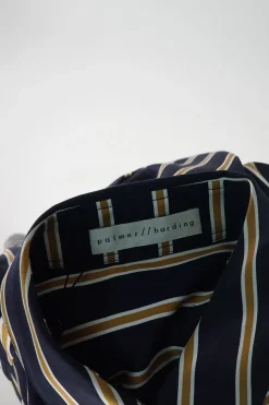 Navy paneled striped cotton poplin wrap-front asymmetric swing-style shift with flounce hem