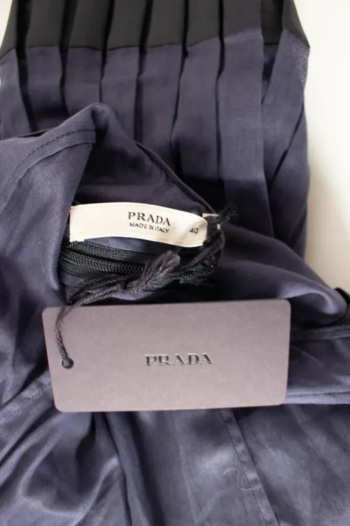 Navy pleated sleeveless knee-length dress with exaggerated tied bow at back