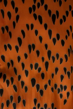 Orange and black tear drop mid-length dress with pleats and, mid-length sleeves and a ruffle neckline