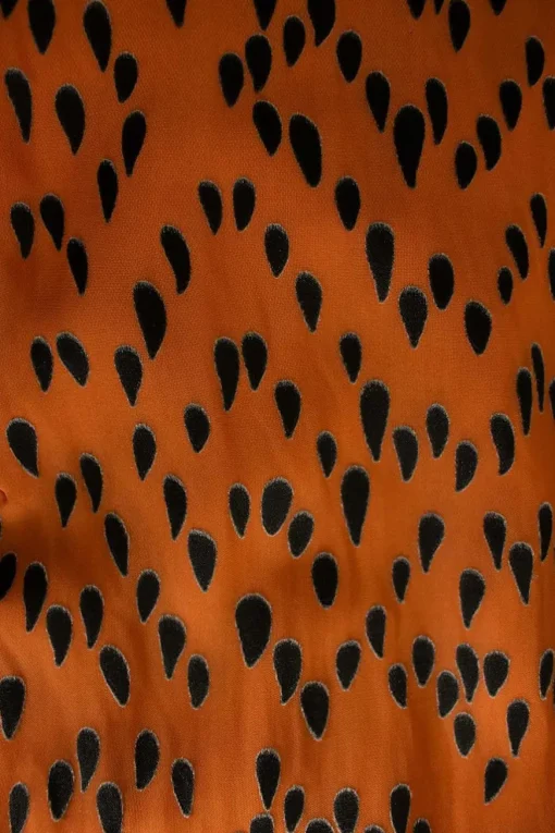 Orange and black tear drop mid-length dress with pleats and, mid-length sleeves and a ruffle neckline