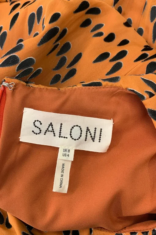 Orange and black tear drop mid-length dress with pleats and, mid-length sleeves and a ruffle neckline