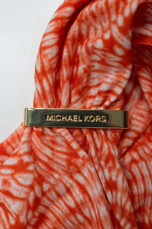 Orange tie dye patterned sleeveless drape top adorned with golden logo debossed hardware on one strap.