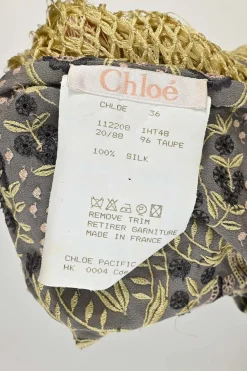 Taupe silk embroidered camisole featuring floral broderie motif with fringe macramé hem