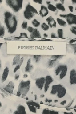 Two-tone silk leopard print cap sleeve blouse with coat of arms shank button appliqué at shoulder line