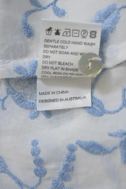 White and blue floral-embroidered semi-sheer cotton lawn half-sleeve swing-style top with button-loop high neck and scalloped edges