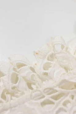 White broderie Anglaise peek-a-boo blouse with ruffled collar, flounce cuffs, and concealed placket